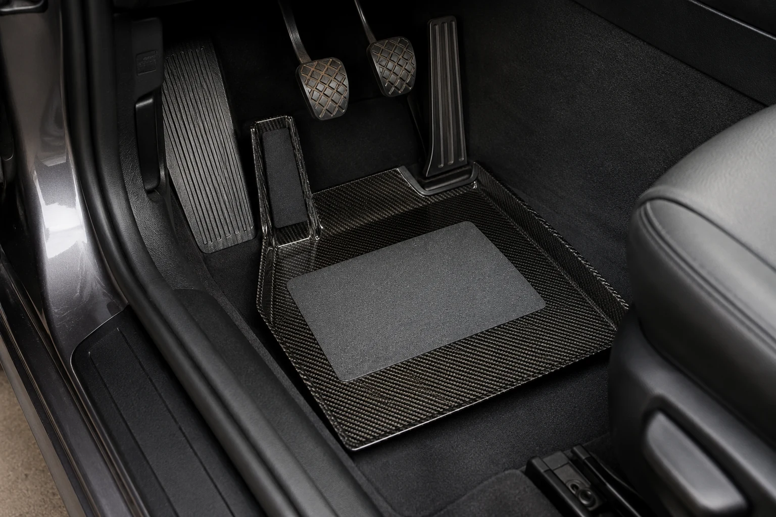 Carbon fiber foot tray installed in a BMW E46 driver footwell