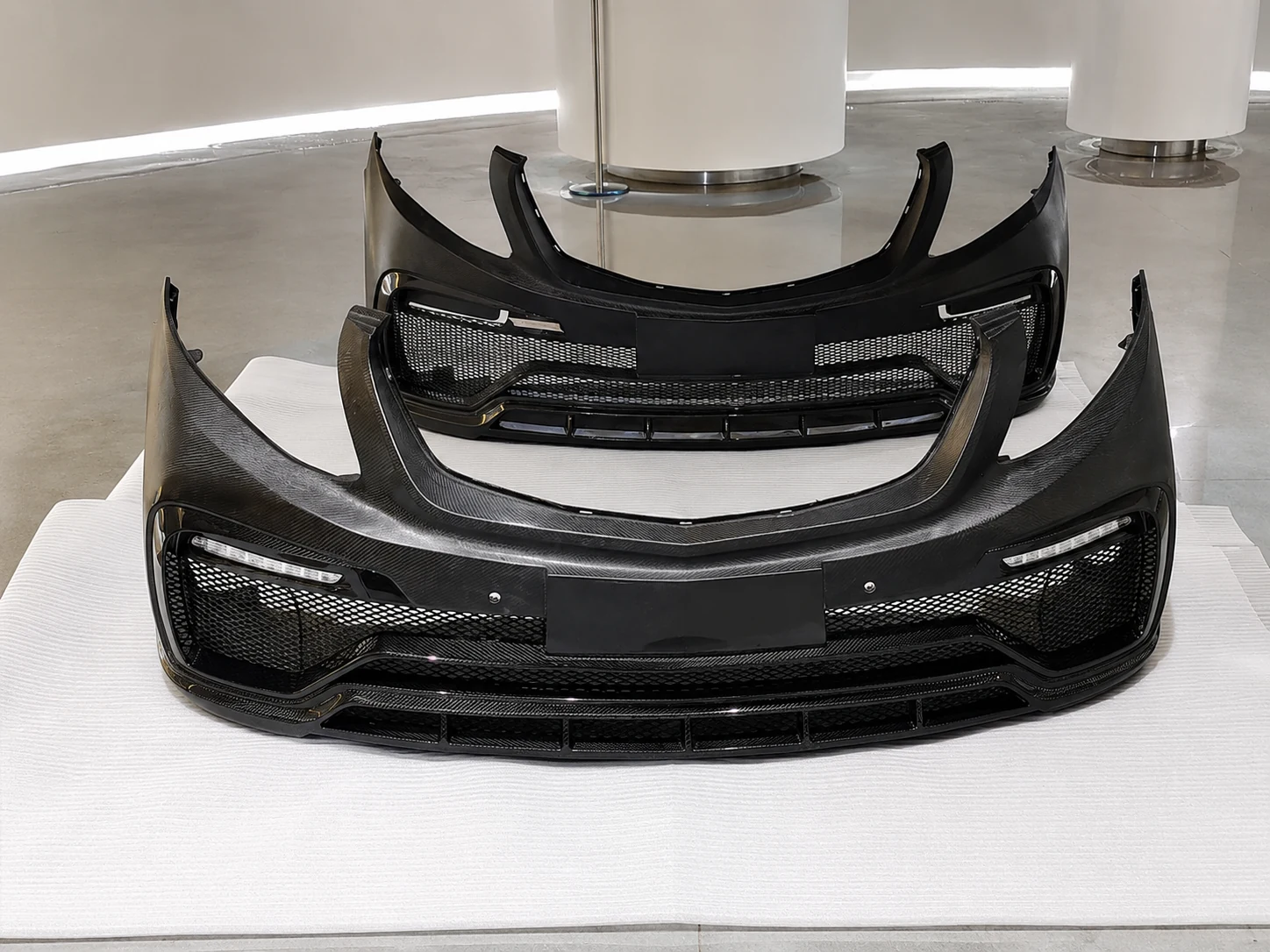 Carbon fiber automotive bumpers arranged for an existing-mold program
