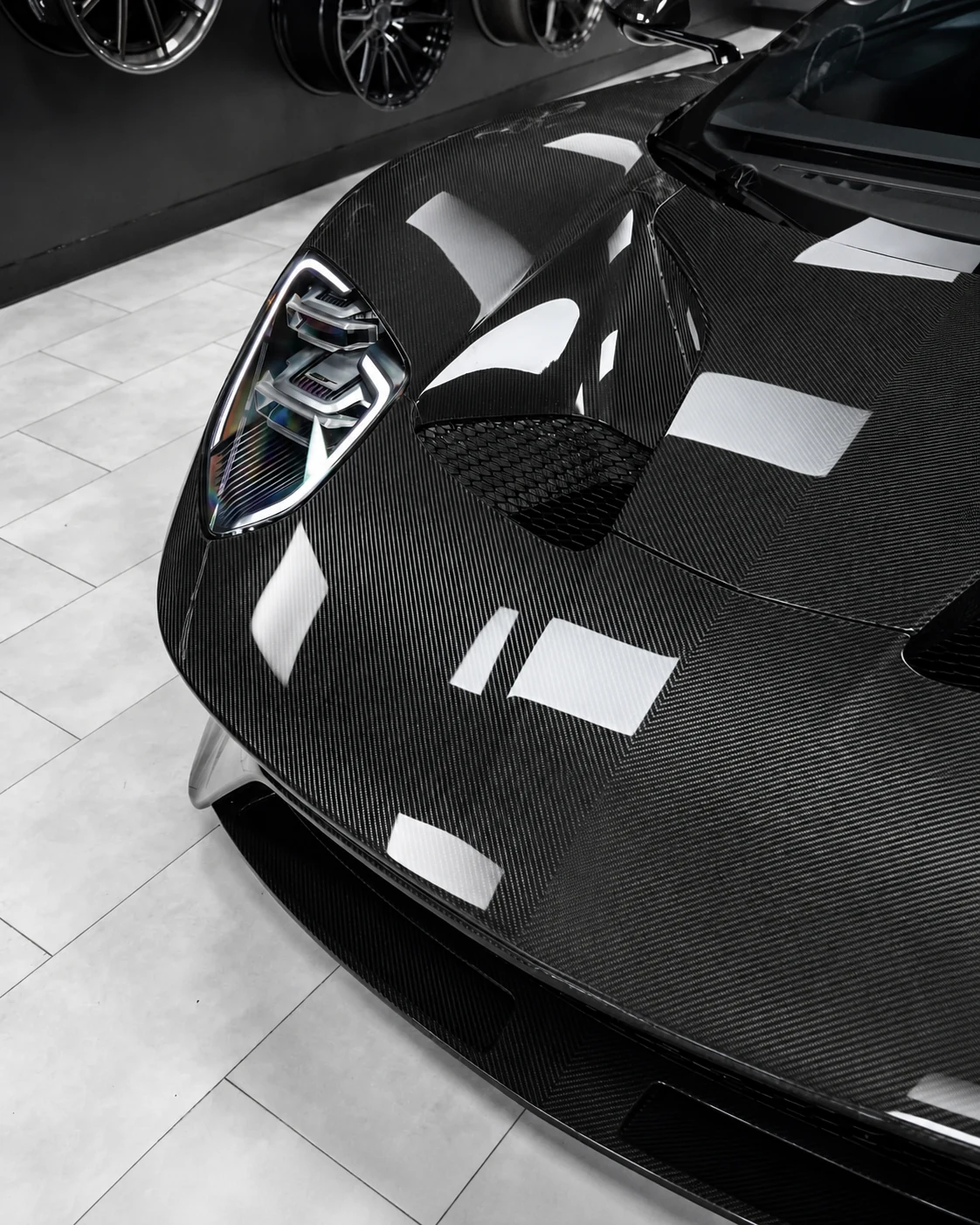 Close-up of a carbon fiber automotive hood with visible woven finish