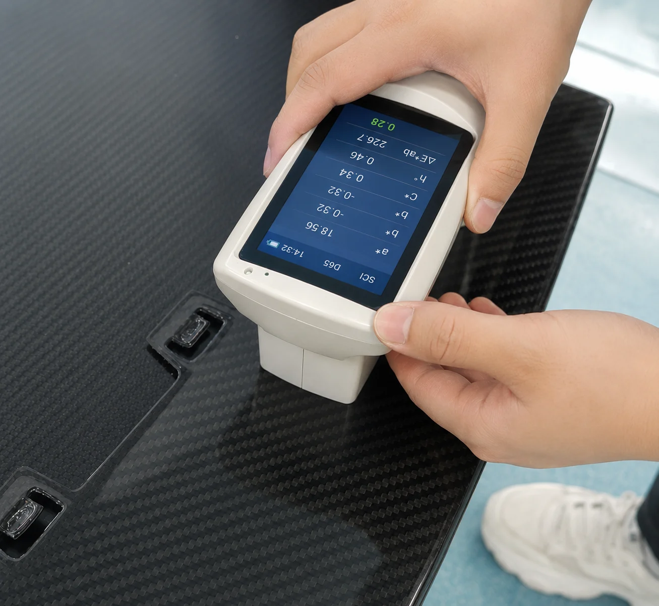 Technician checking the surface of a carbon fiber panel with a handheld inspection instrument