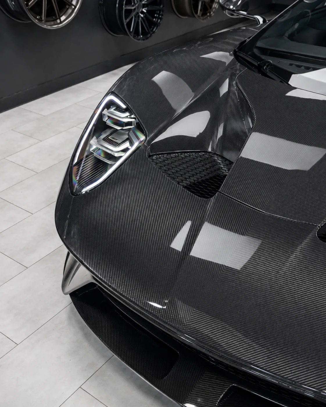 Gloss carbon fiber automotive hood installed on a sports car