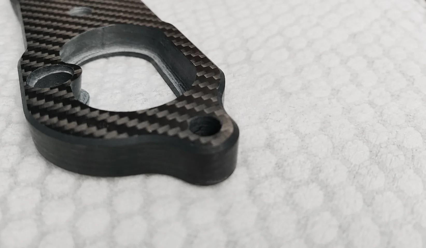 Machined carbon fiber bracket representing a process and material alternative