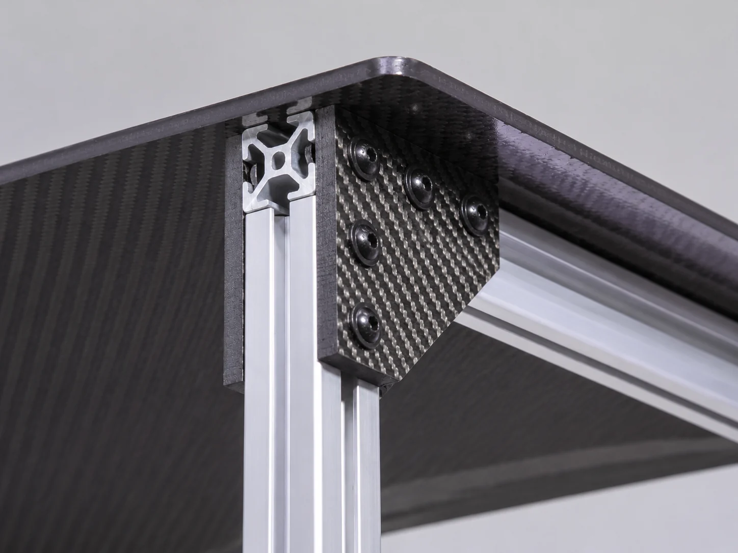 Carbon fiber corner joint with local reinforcement and mechanical fasteners
