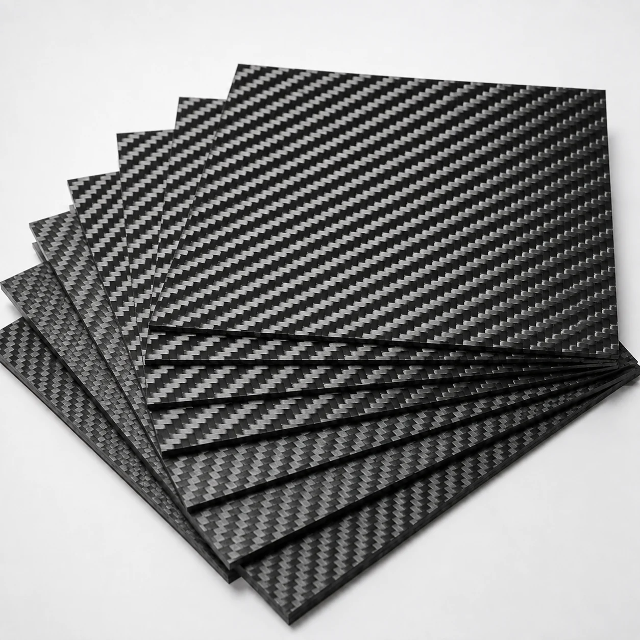 Stacked carbon fiber plates with visible woven surfaces and edges