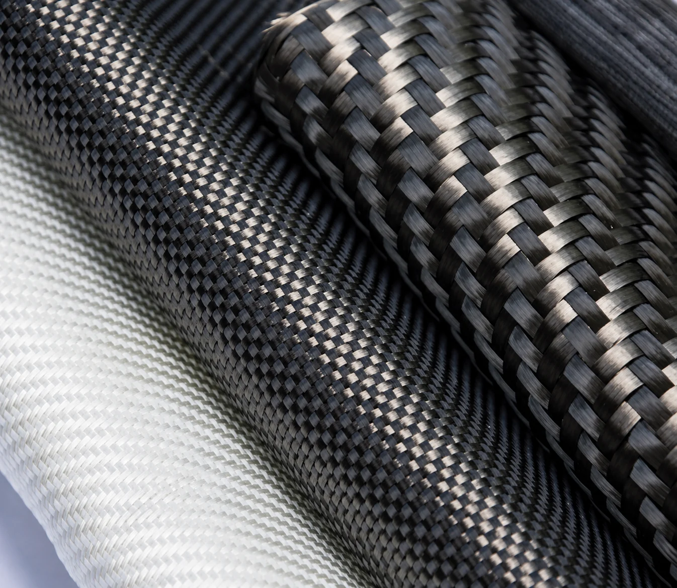 Carbon fiber reinforcements with distinct woven and braided arrangements