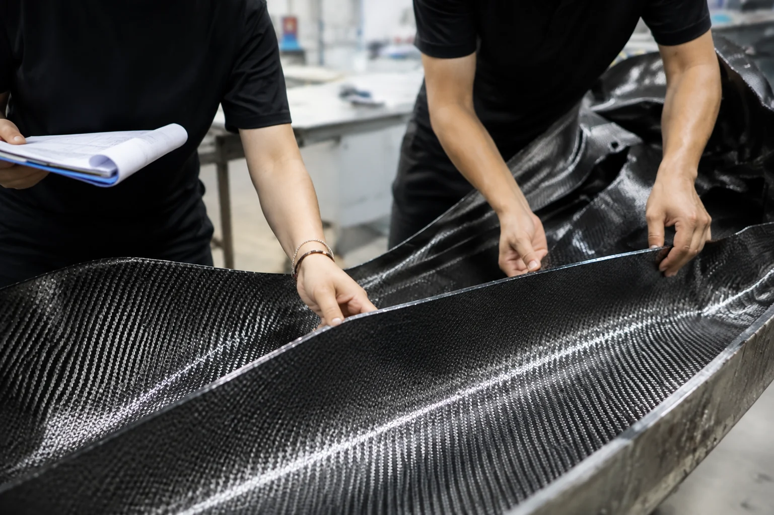 Technical team reviewing carbon fiber material and project information